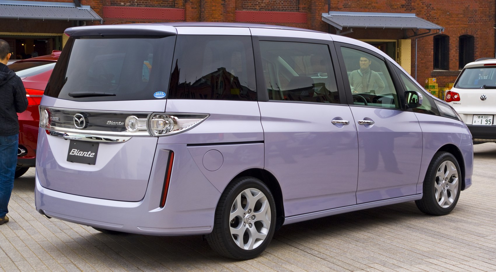 Rear and side view of a minivan with sliding doors and distinct taillights