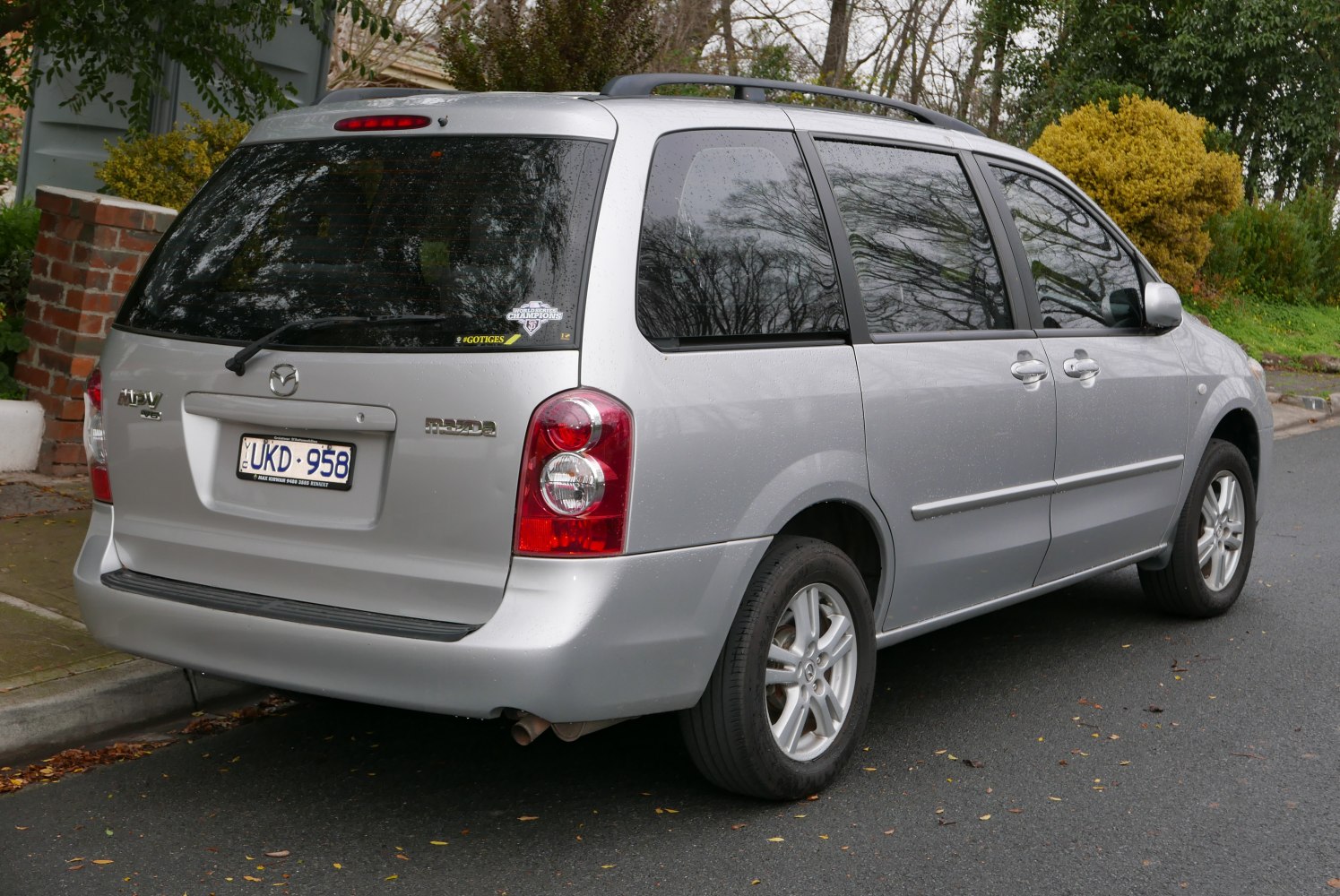 Silver minivan rear side with distinct rear lights and tinted windows