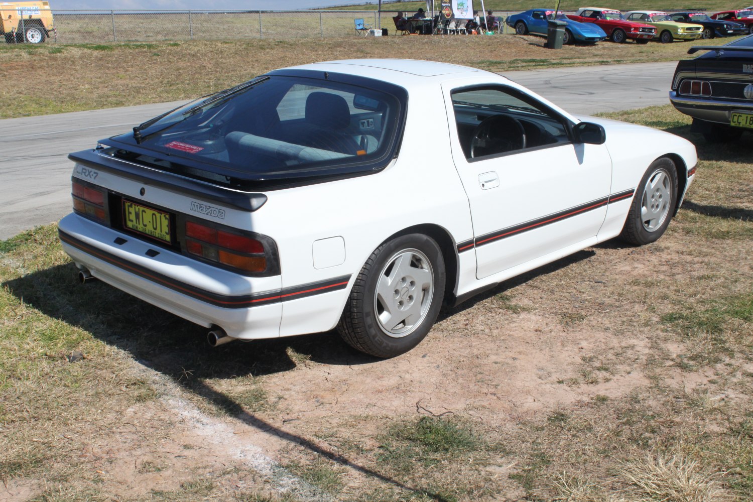 Rear side view of white sports coupe with distinctive taillights and sporty design