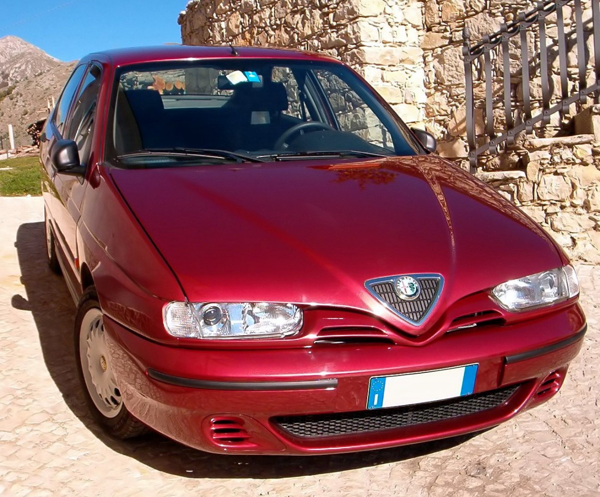 Front view of red hatchback with distinctive grille and headlights