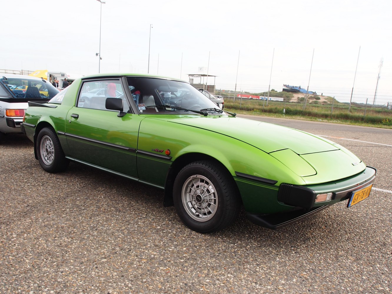 Vintage green coupe with pop-up headlights and classic alloy wheels