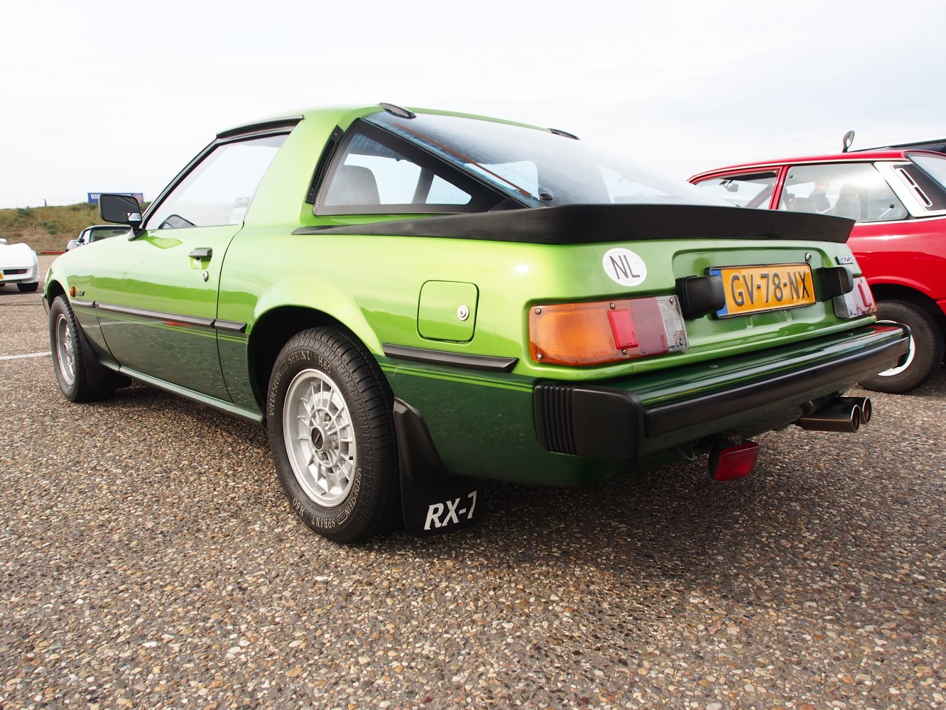 Rear and side view of vintage sports coupe with signature tail lights and rear spoiler.