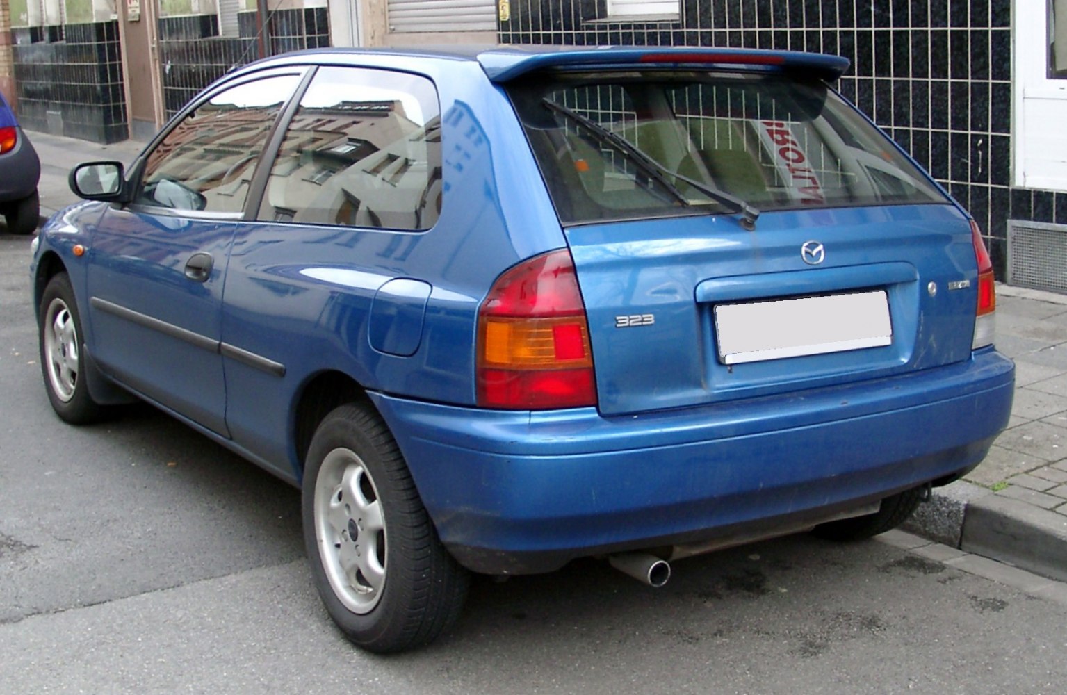 Rear view of blue hatchback with rear wiper and distinct tail lights