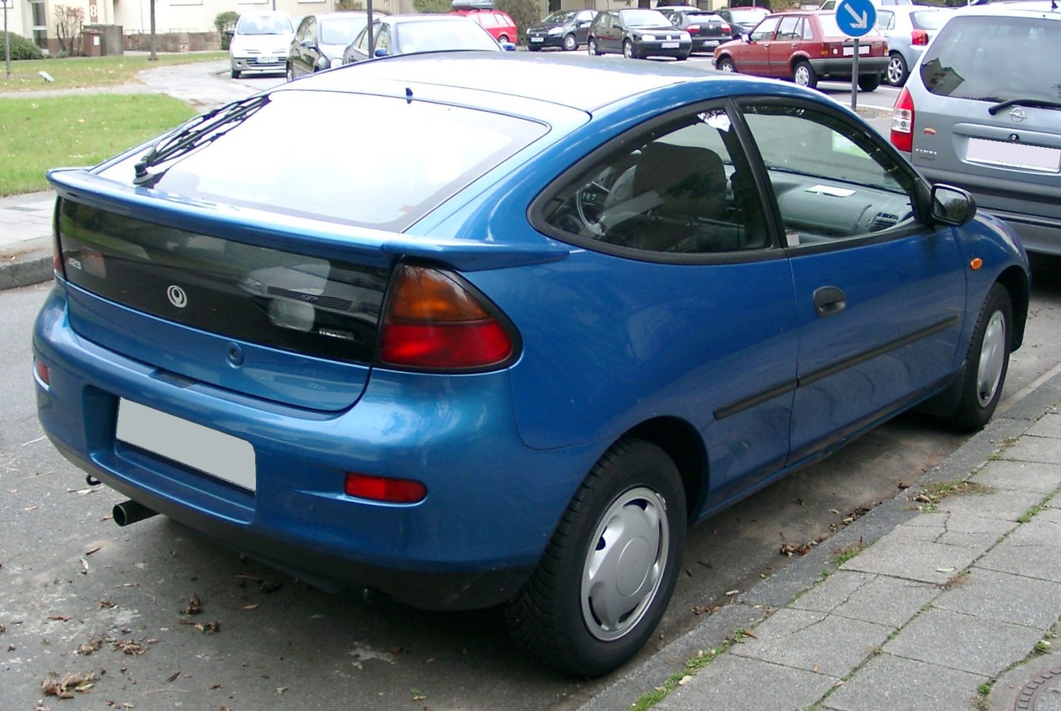Rear and side view of a blue compact hatchback with spoiler and black tail panel