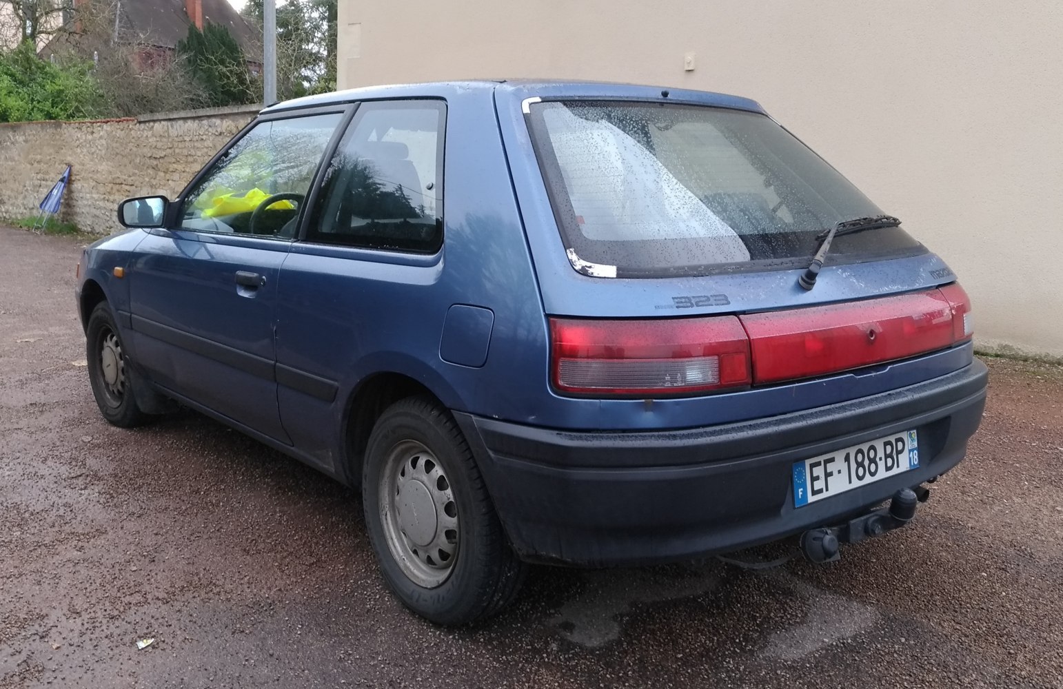 Rear view of an older hatchback with distinctive tail lights