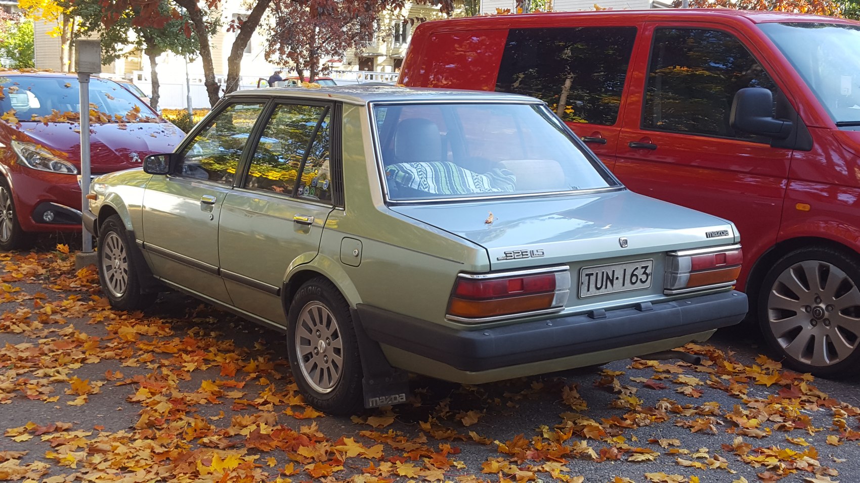 Rear view of a sharp-edged compact sedan with rectangular tail lights and mud flaps.