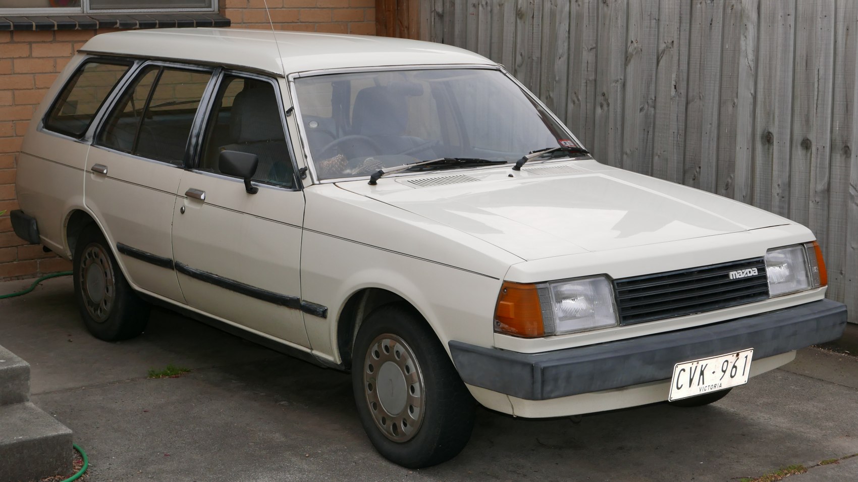 Rectangular headlights and black grille on vintage station wagon with roof rails.