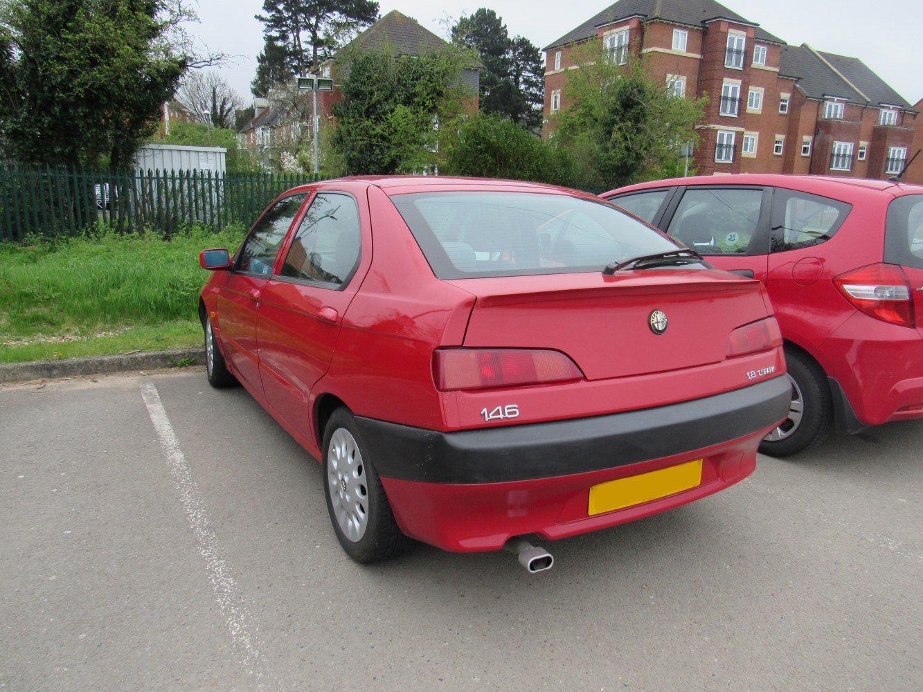 Rear view showing taillights, rear spoiler, and exhaust pipe of a compact hatchback.