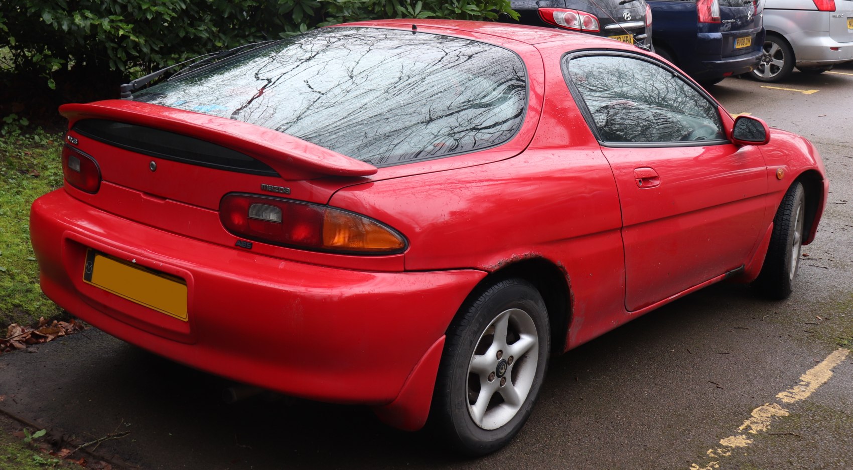 Rear three-quarter view of red sports coupe with spoiler