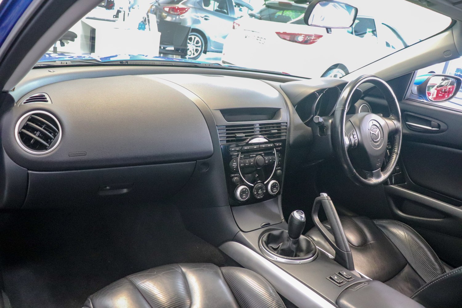 Mazda RX-8 interior with manual gear shift and dashboard