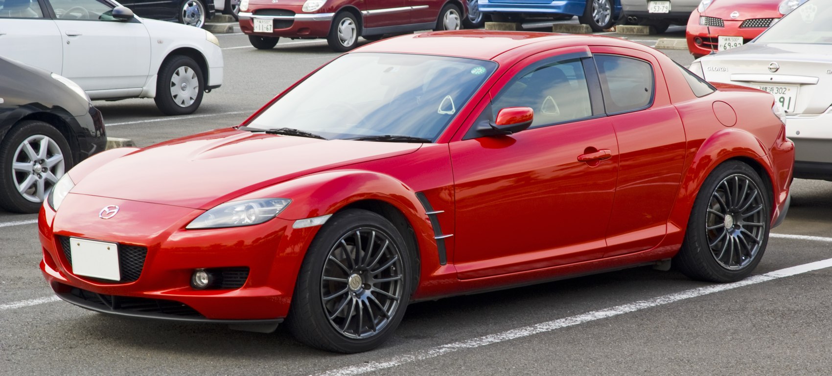 Red sports coupe with black multi-spoke alloy wheels and aerodynamic styling