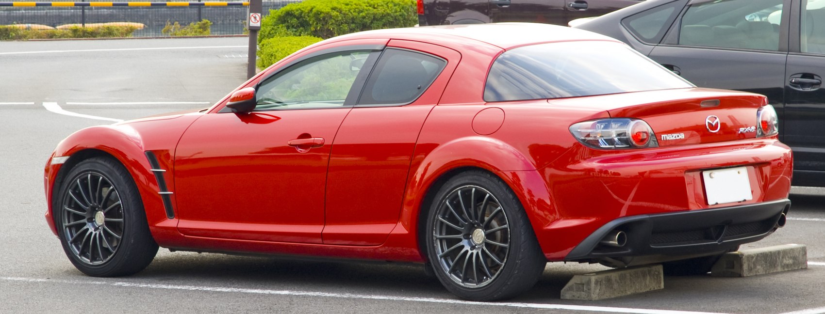 Side and rear view of sporty coupe with rear-hinged doors and alloy wheels