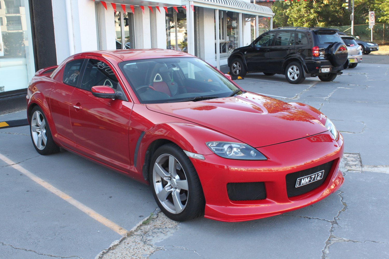 Red sports coupe with aerodynamic front bumper and five-spoke wheels