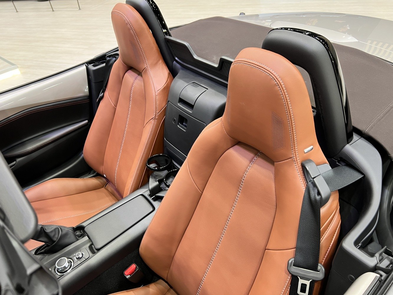 Brown leather seats and center console with seatbelt in convertible interior