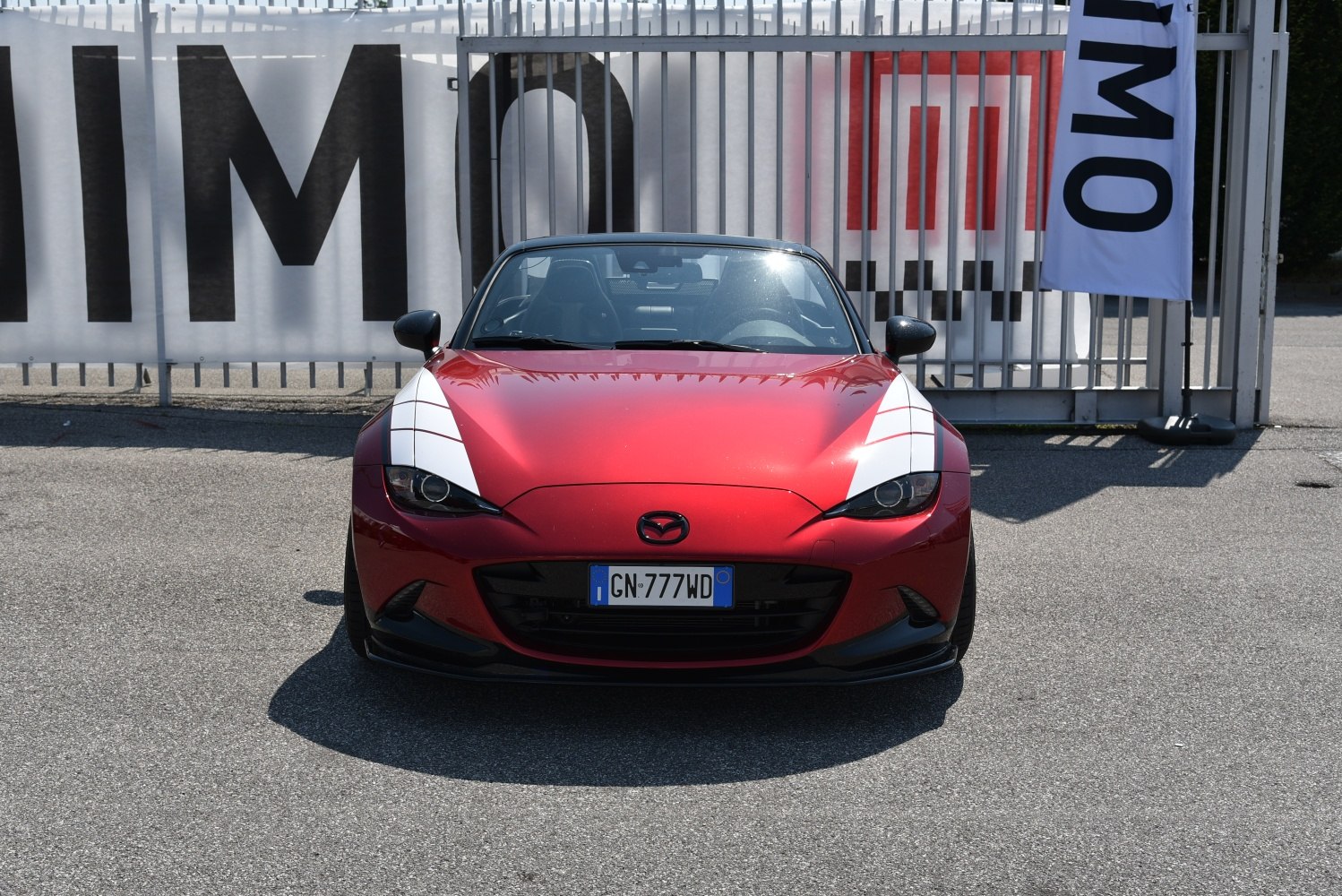 Front view of red convertible with white racing stripes and sleek headlights