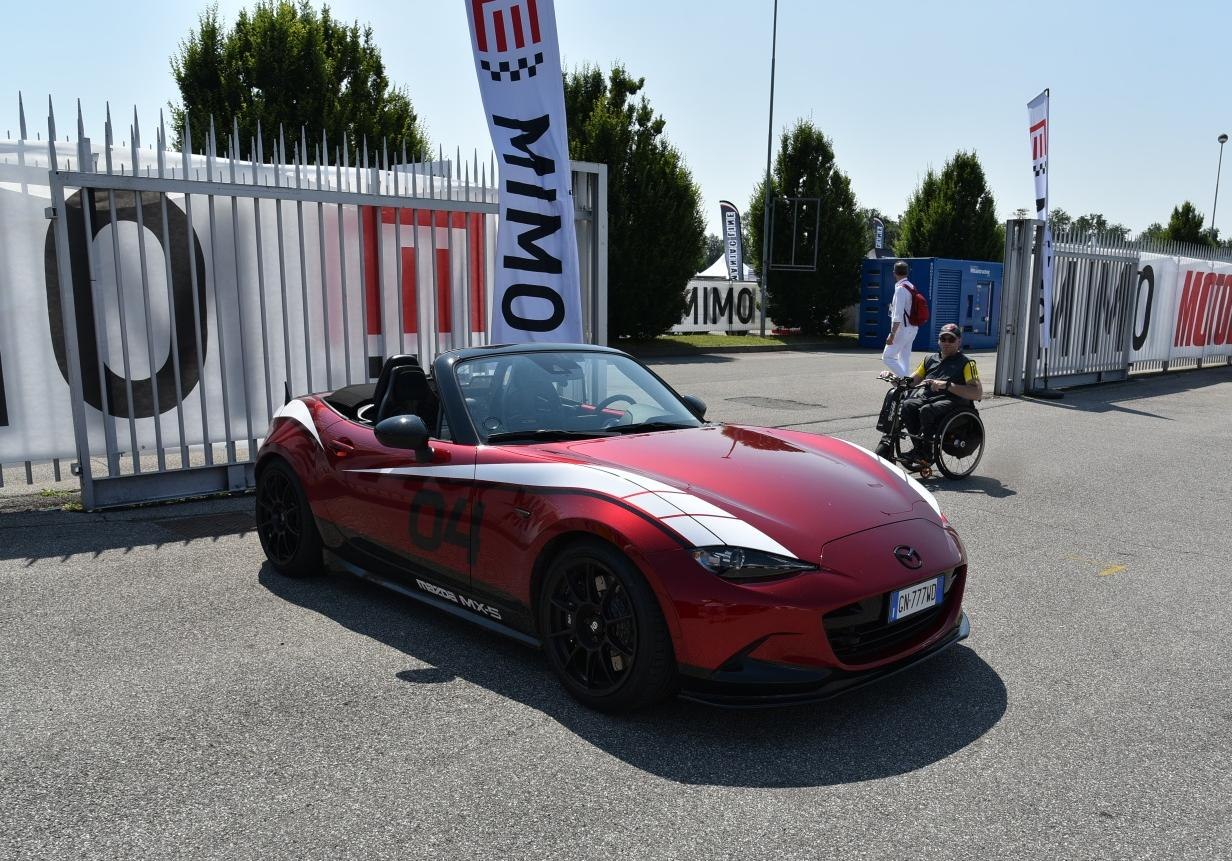 Red convertible roadster with white racing stripes and black wheels
