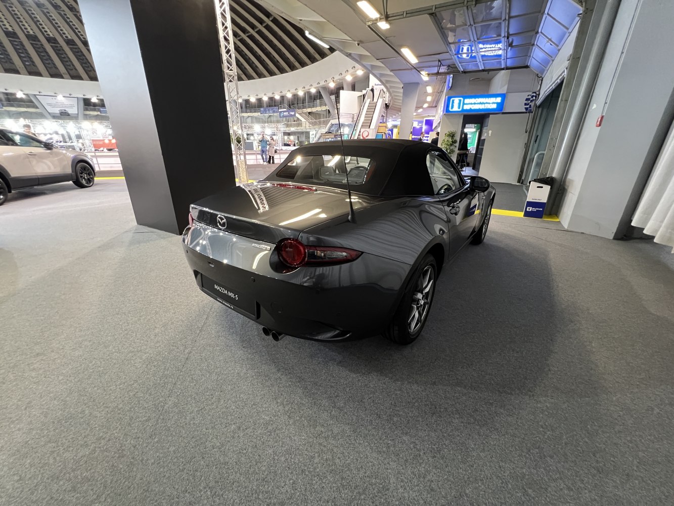 Rear view of a soft top convertible with round taillights and dual exhausts