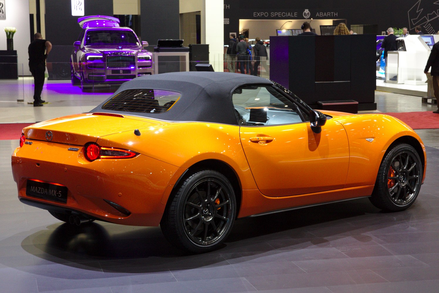 Orange convertible with black soft top and dark alloy wheels