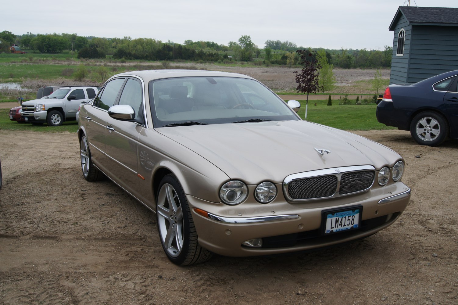 Quad round headlights and mesh front grille on a luxury sedan front.