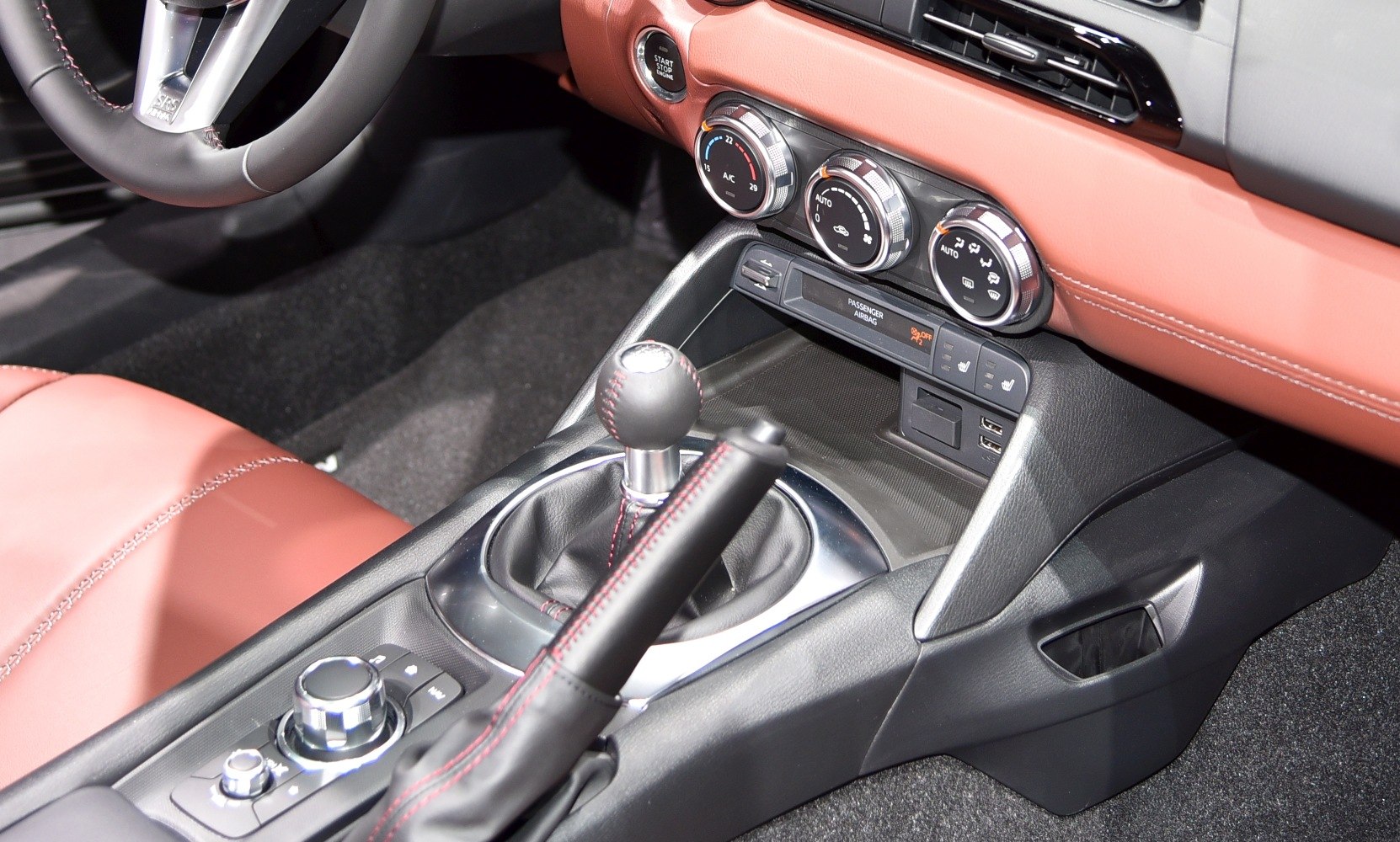 Manual gear shift and climate control panel in a leather-finished car interior