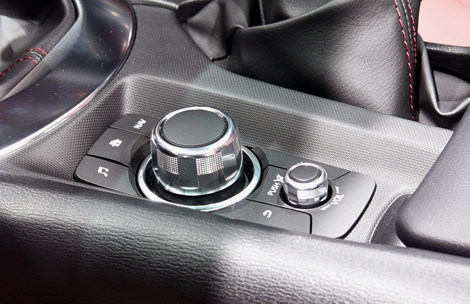 Multimedia control knobs and buttons with textured surface and leather surrounding.