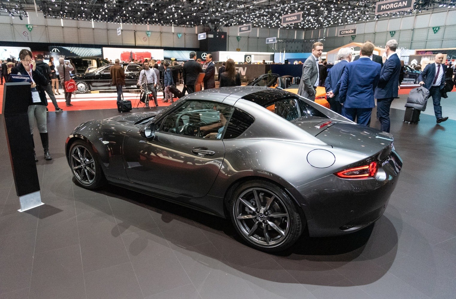 Gray hardtop coupe with sleek aerodynamic design and sporty alloy wheels.