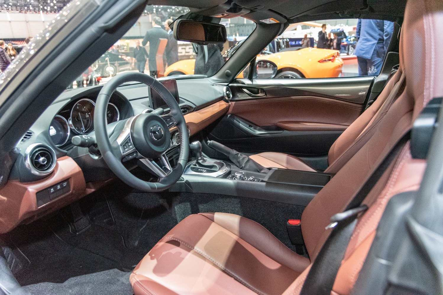 Modern car interior with brown leather seats and center console.