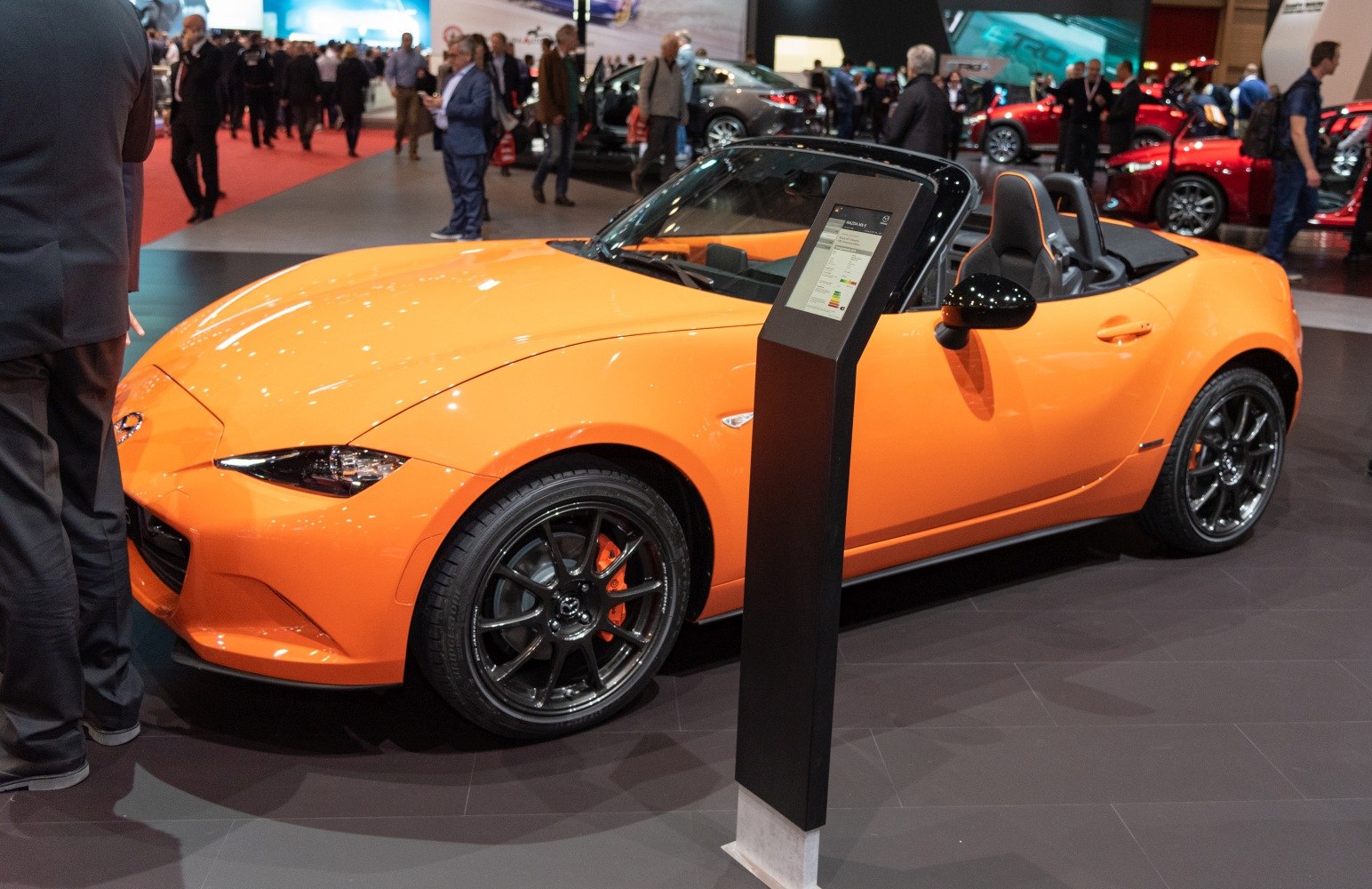 Orange convertible with black alloy wheels and open-top interior