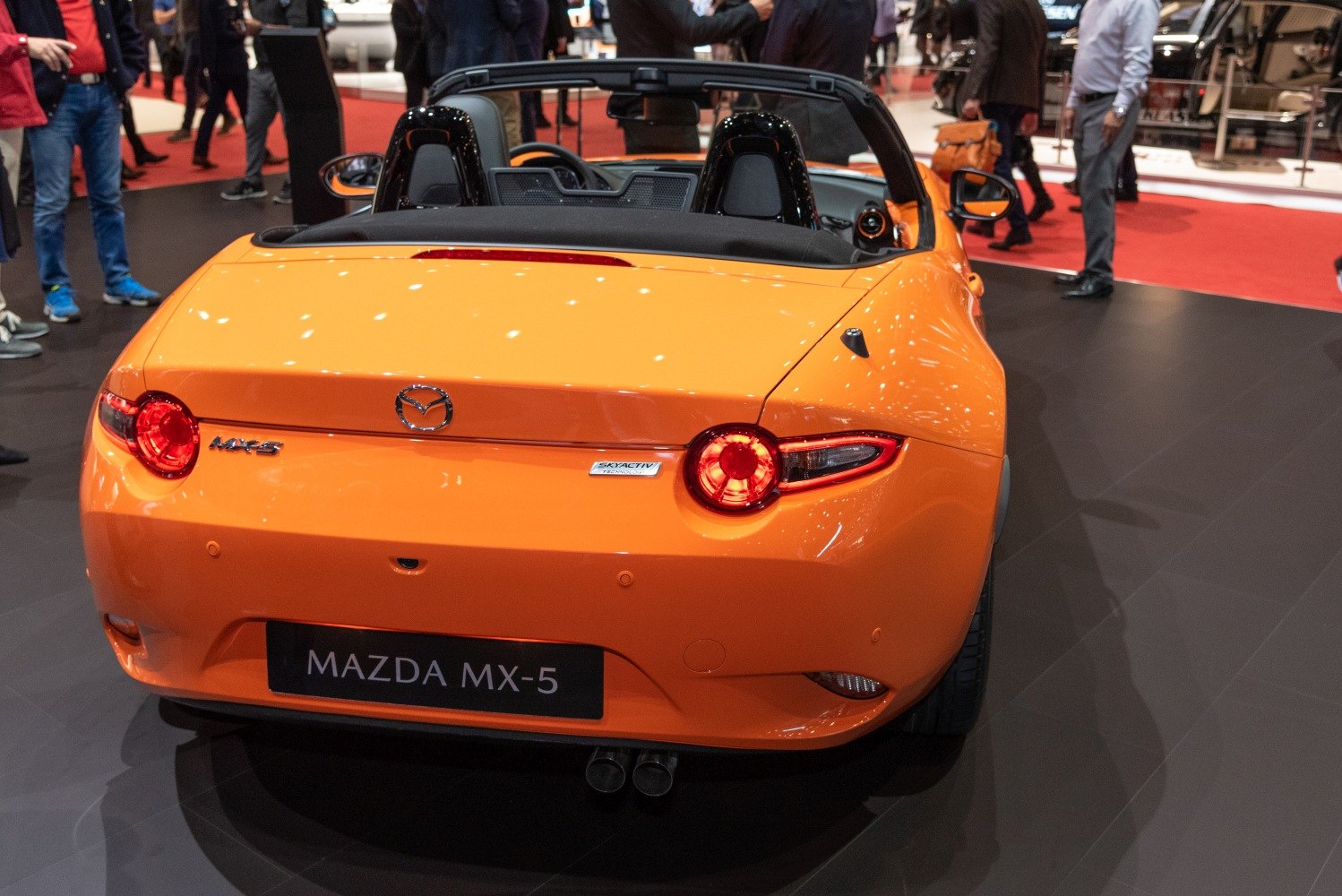 Bright orange convertible rear with round taillights and dual exhausts