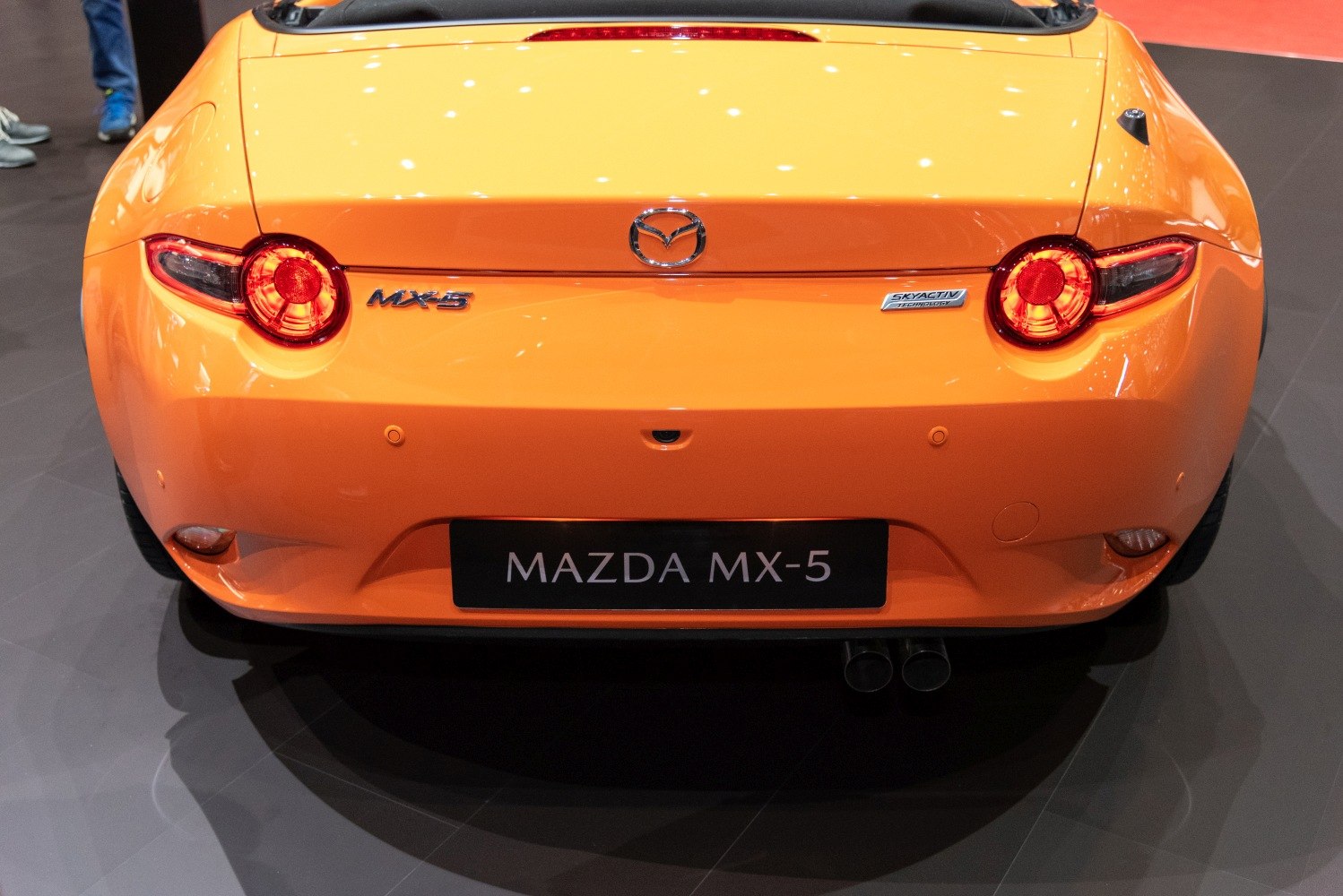 Rear view with round taillights and dual exhaust in orange finish