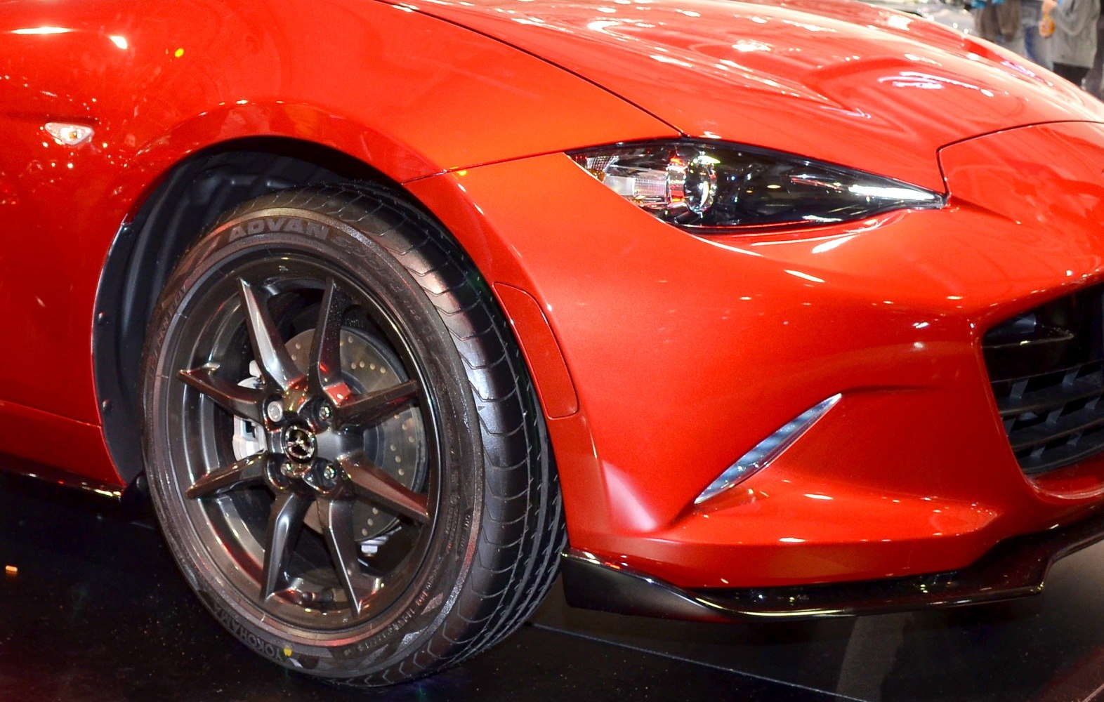 Close-up of front headlight and alloy wheel with sport design