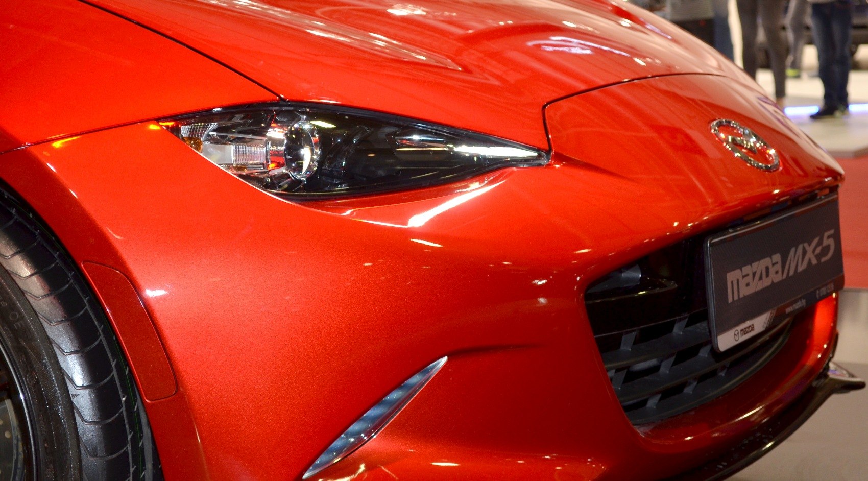 Close-up of front headlight and grille of a red sports car