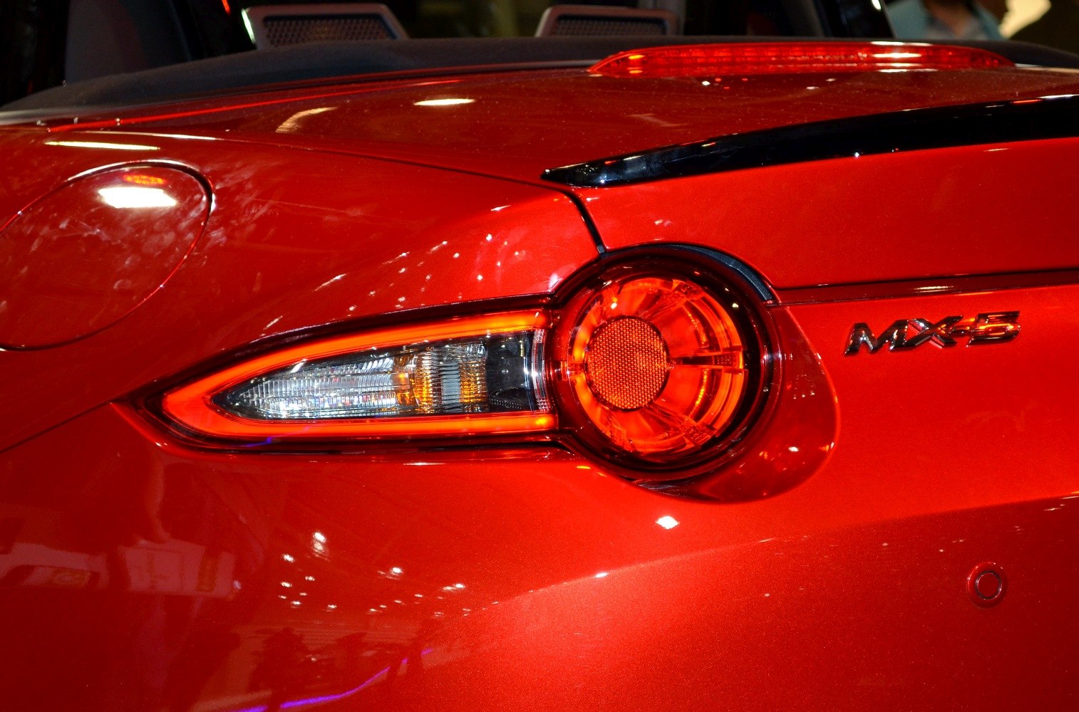 Close-up of sporty red car's detailed taillight and rear badge