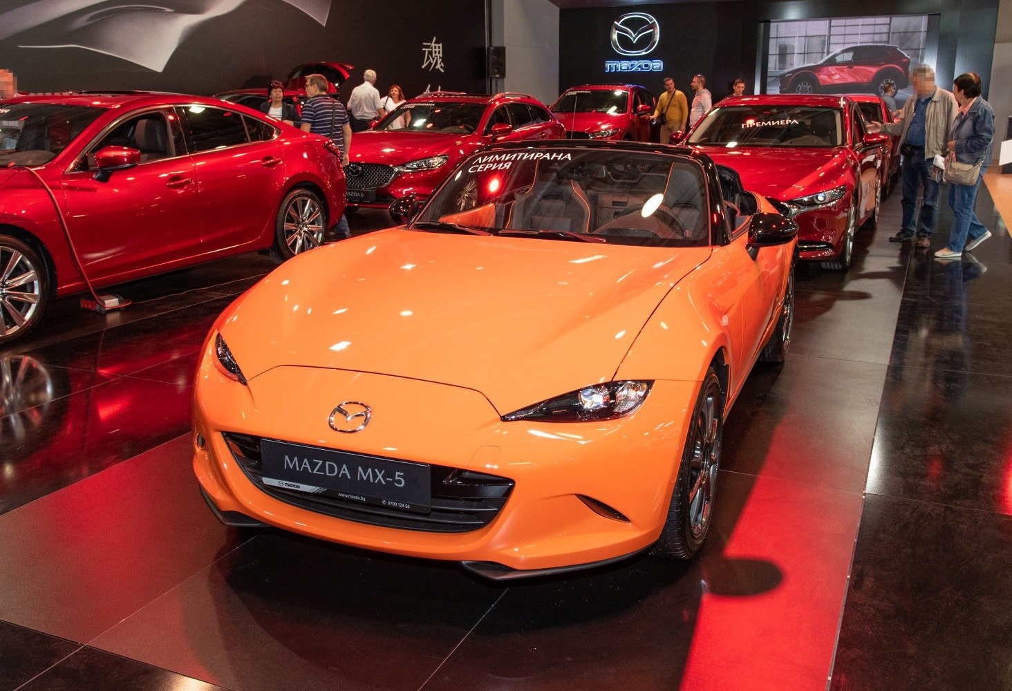 Front view of orange convertible with sleek headlights and sporty design