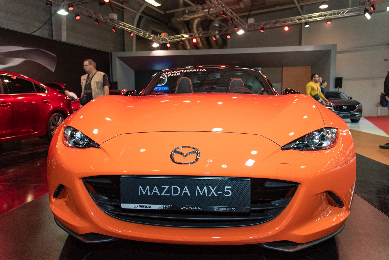 Bright orange sports coupe front with sleek headlights and grille