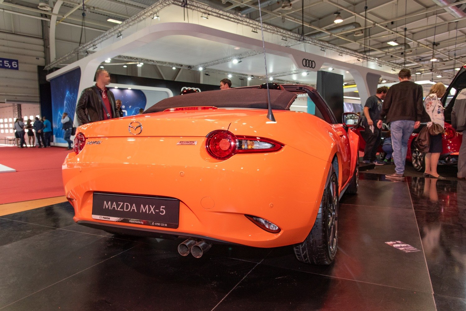Rear view of orange convertible with dual exhaust and round tail lights