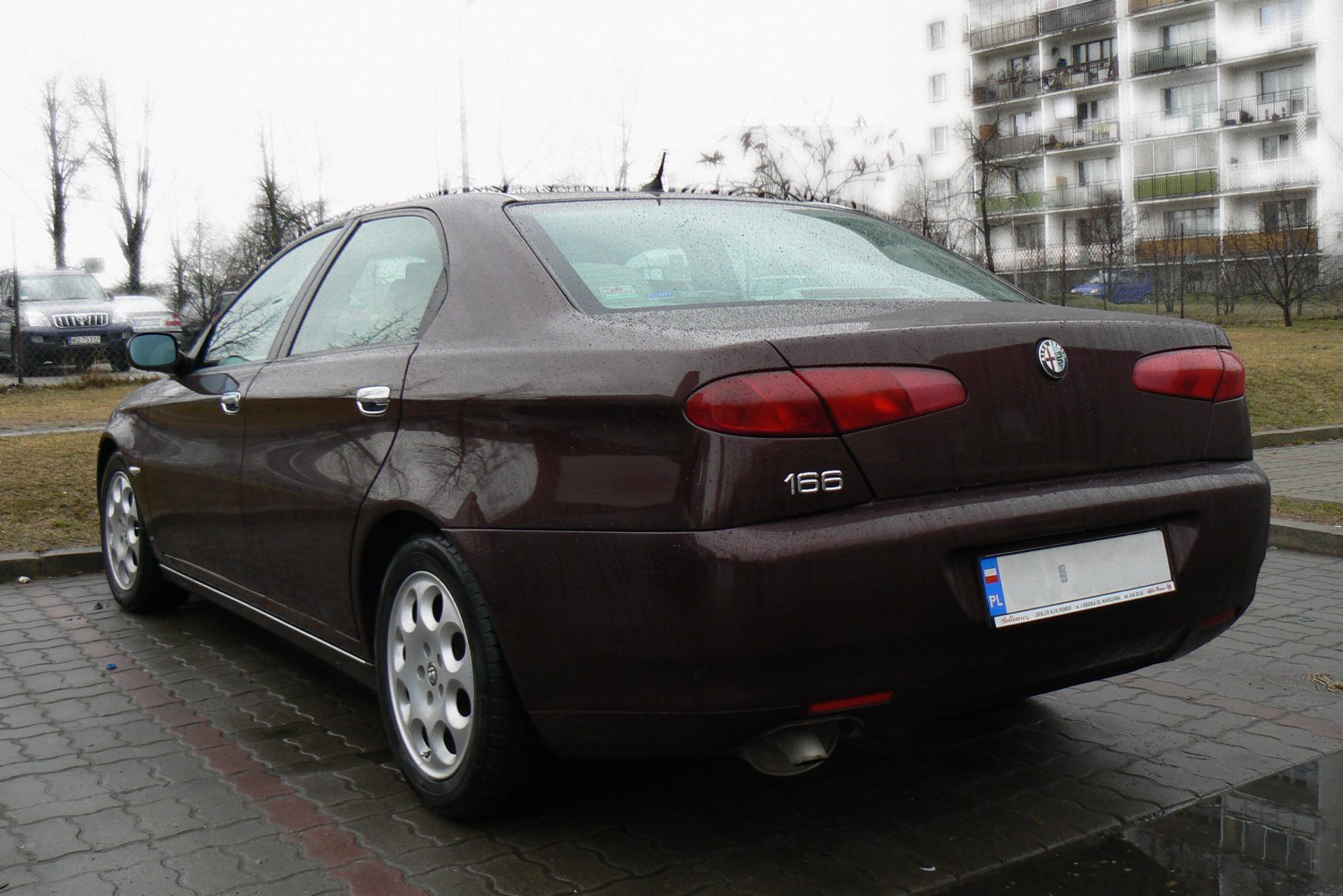 Rear-side view of sedan with rounded taillights and alloy wheels
