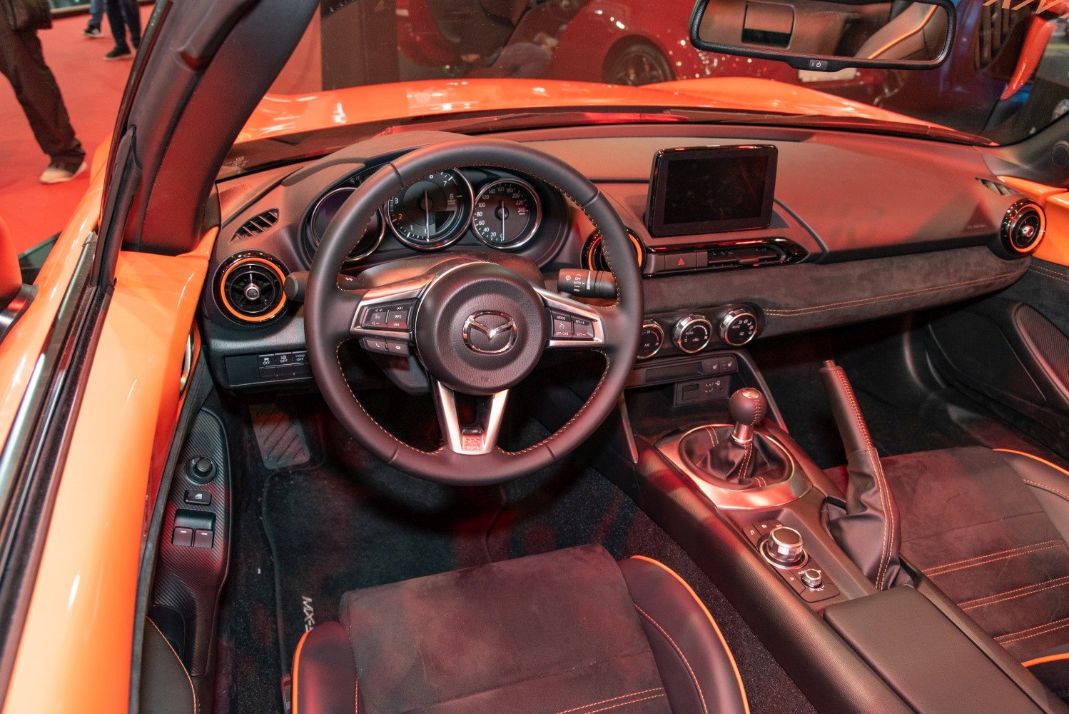 Steering wheel, dashboard, and center console with manual gearshift.