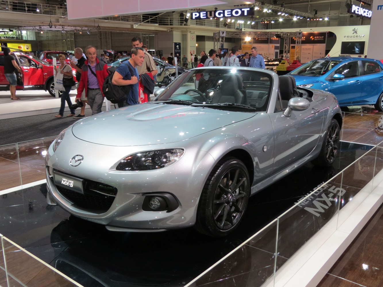 Silver convertible roadster with sleek headlights and alloy wheels