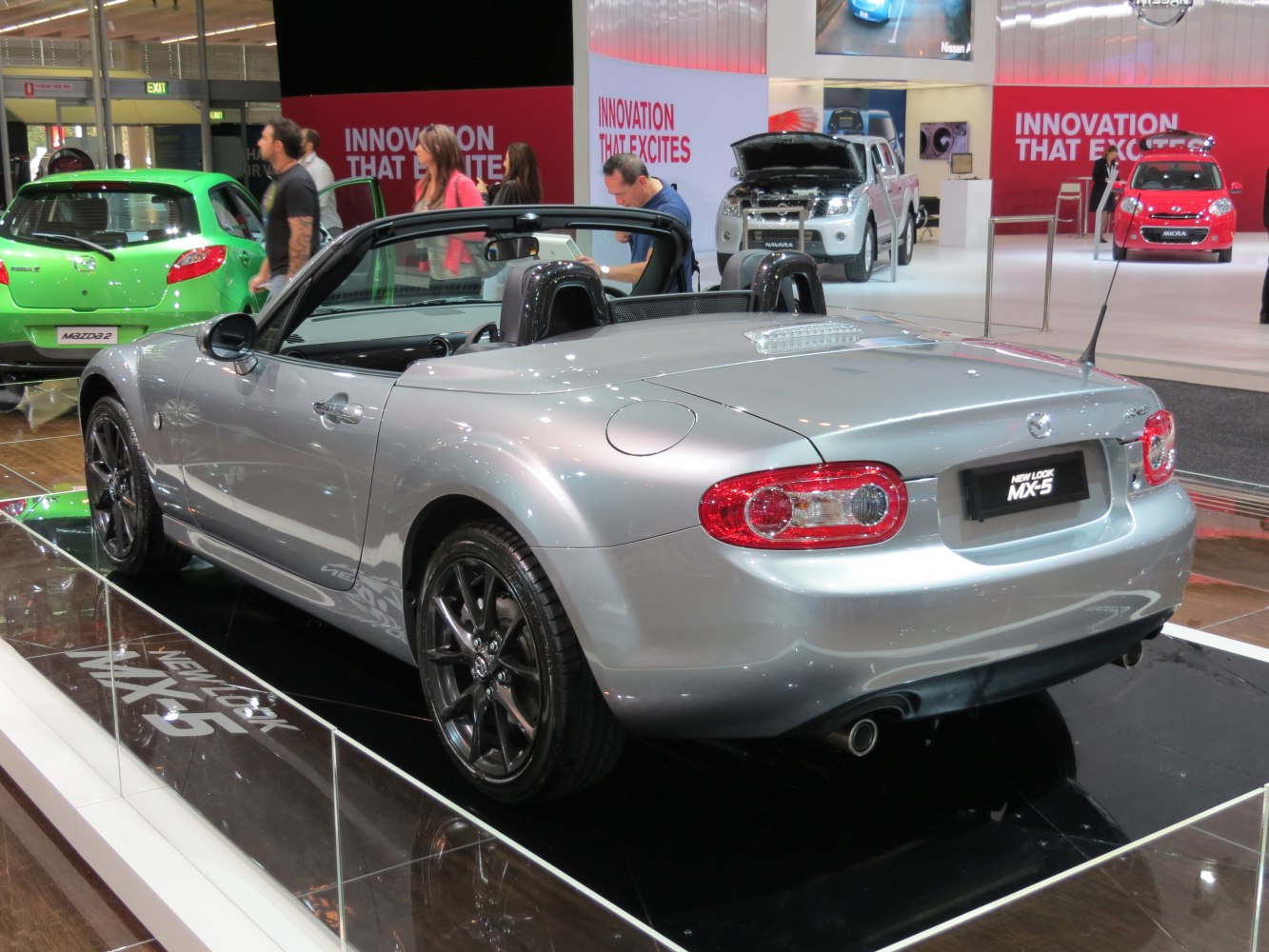 Rear view of a silver convertible with black wheels and distinct taillights
