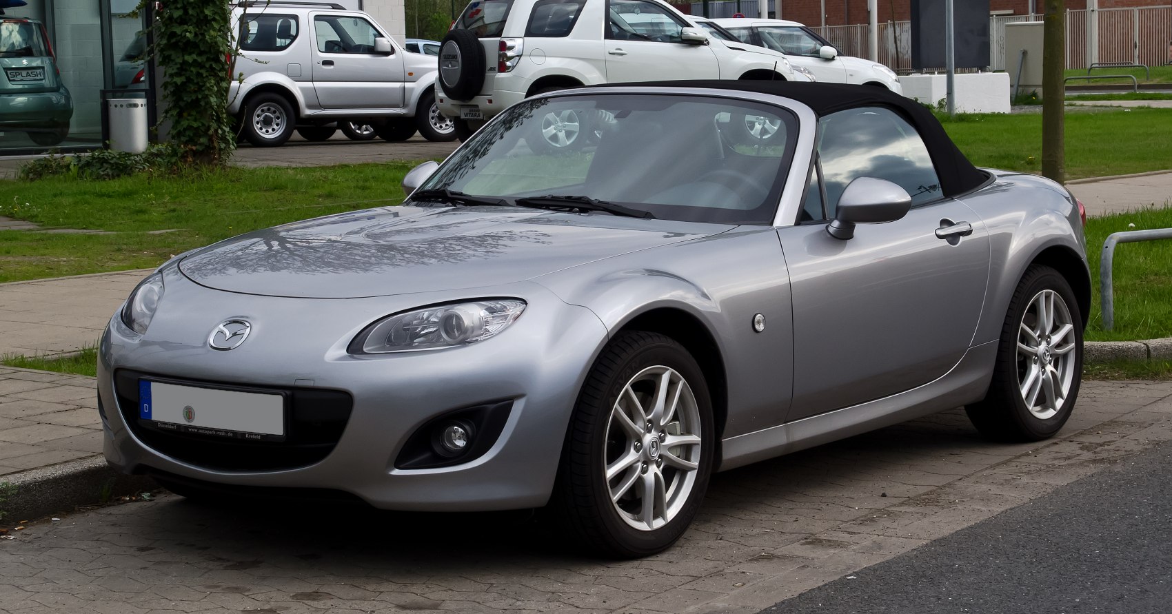 Silver convertible with front view, alloy wheels, and headlights