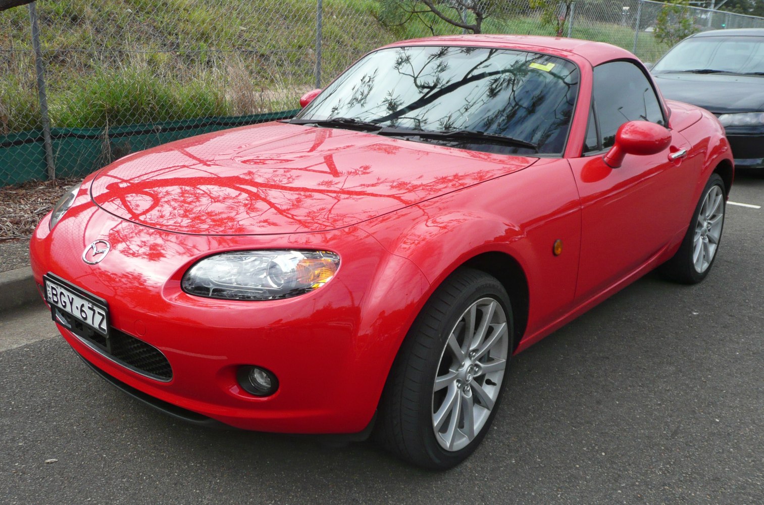 Red convertible sports car with alloy wheels and sleek headlights