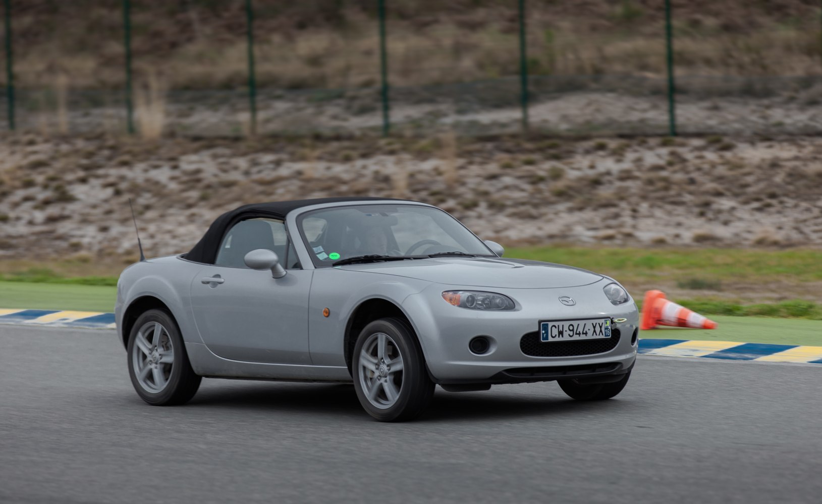 Silver lightweight two-seater convertible with black soft top