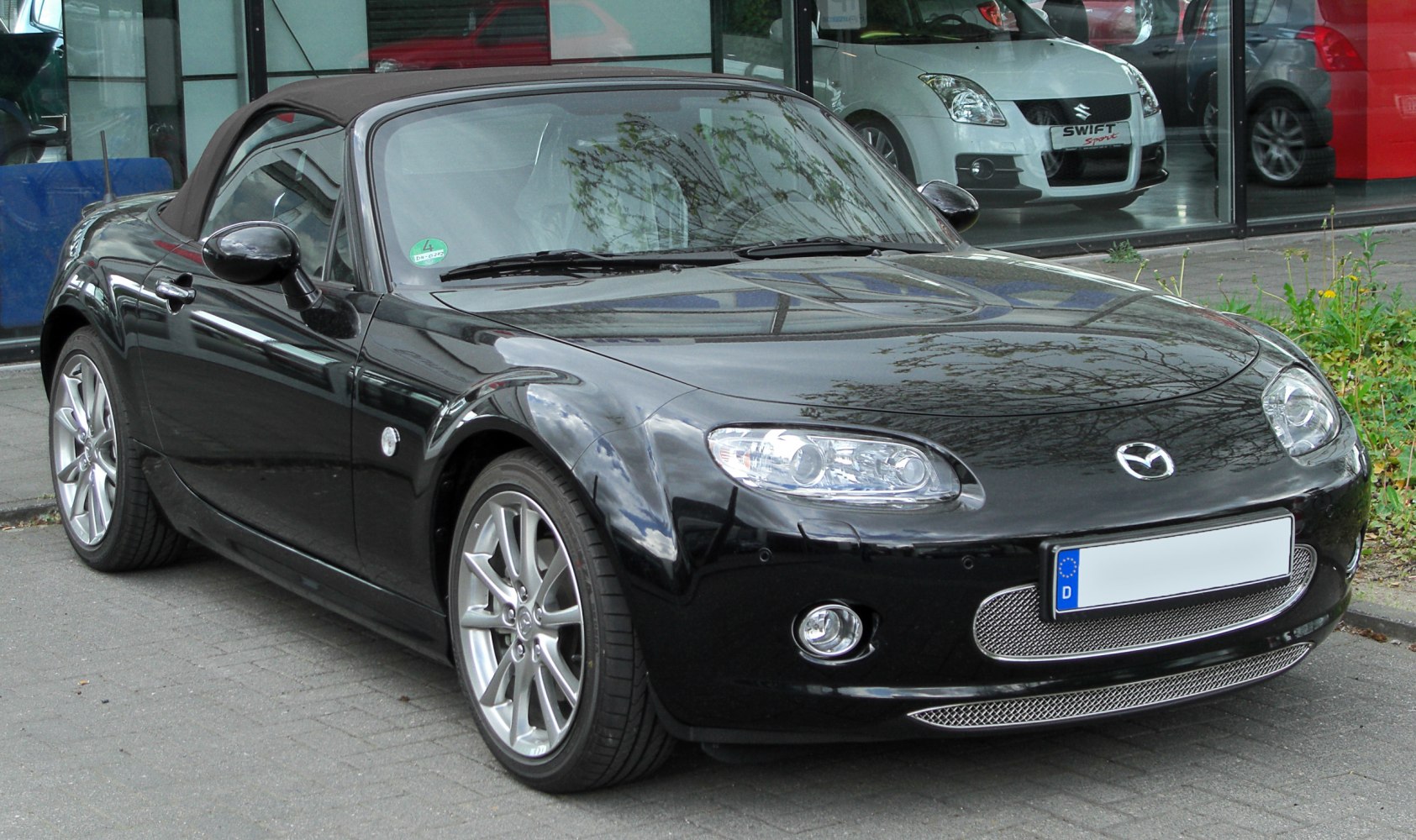 Black roadster convertible with alloy wheels and distinct headlights