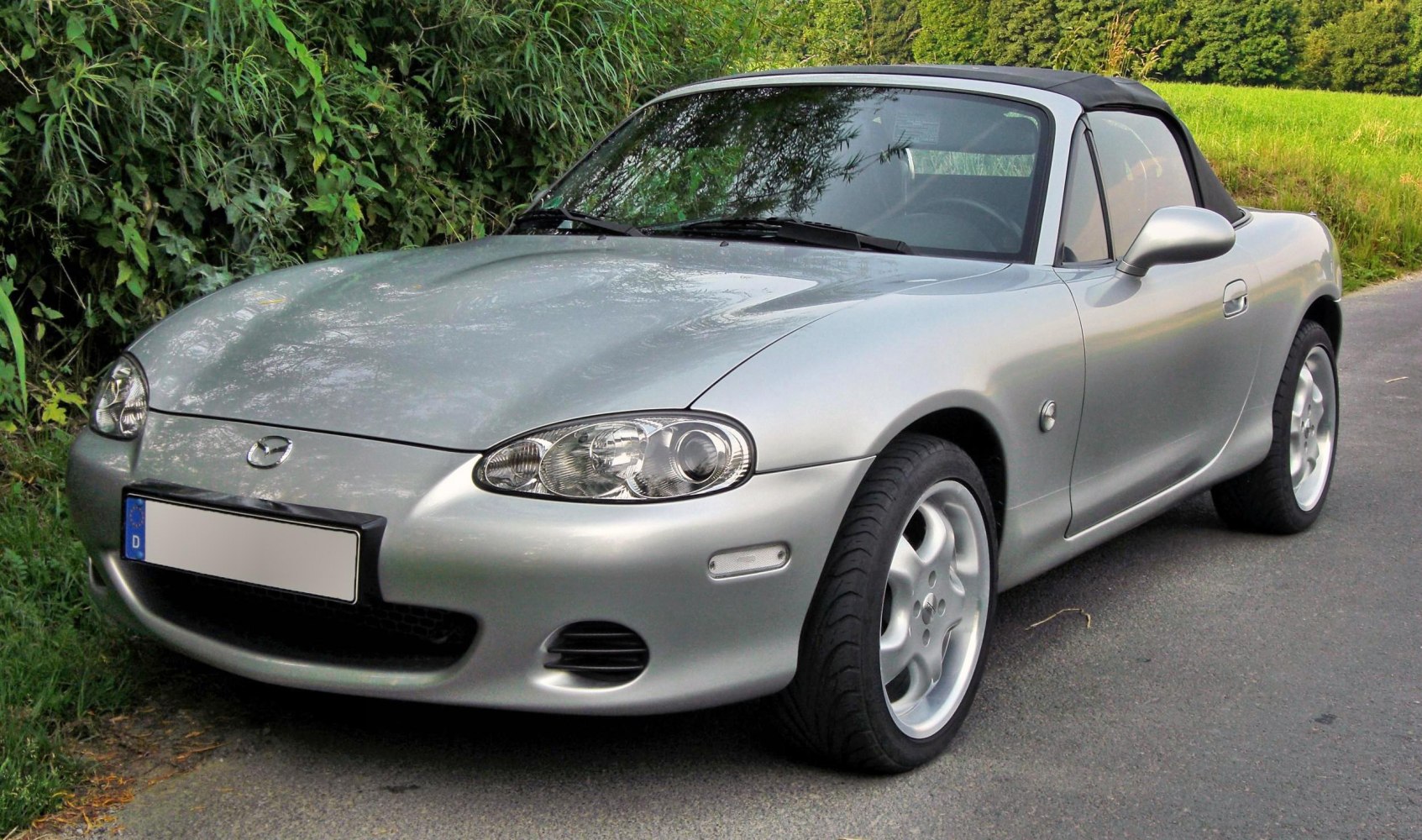 Silver convertible with soft top, front-left angle, alloy wheels