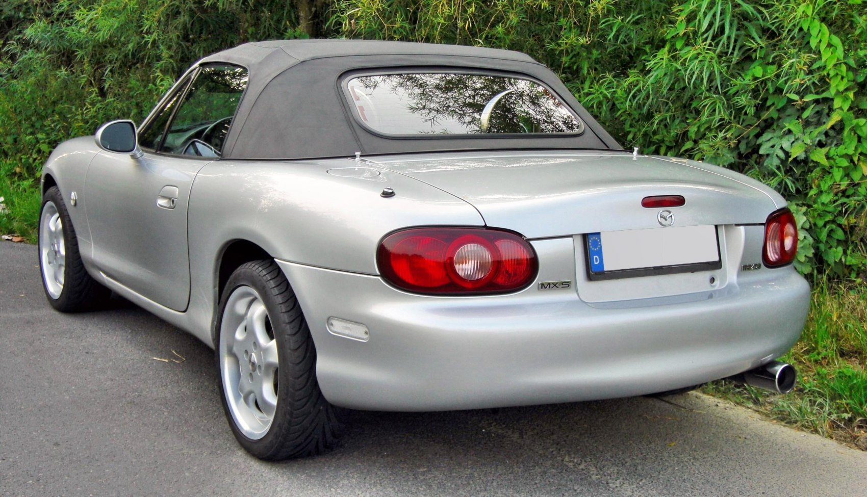 Rear view of soft top convertible with distinct taillights and alloy wheels