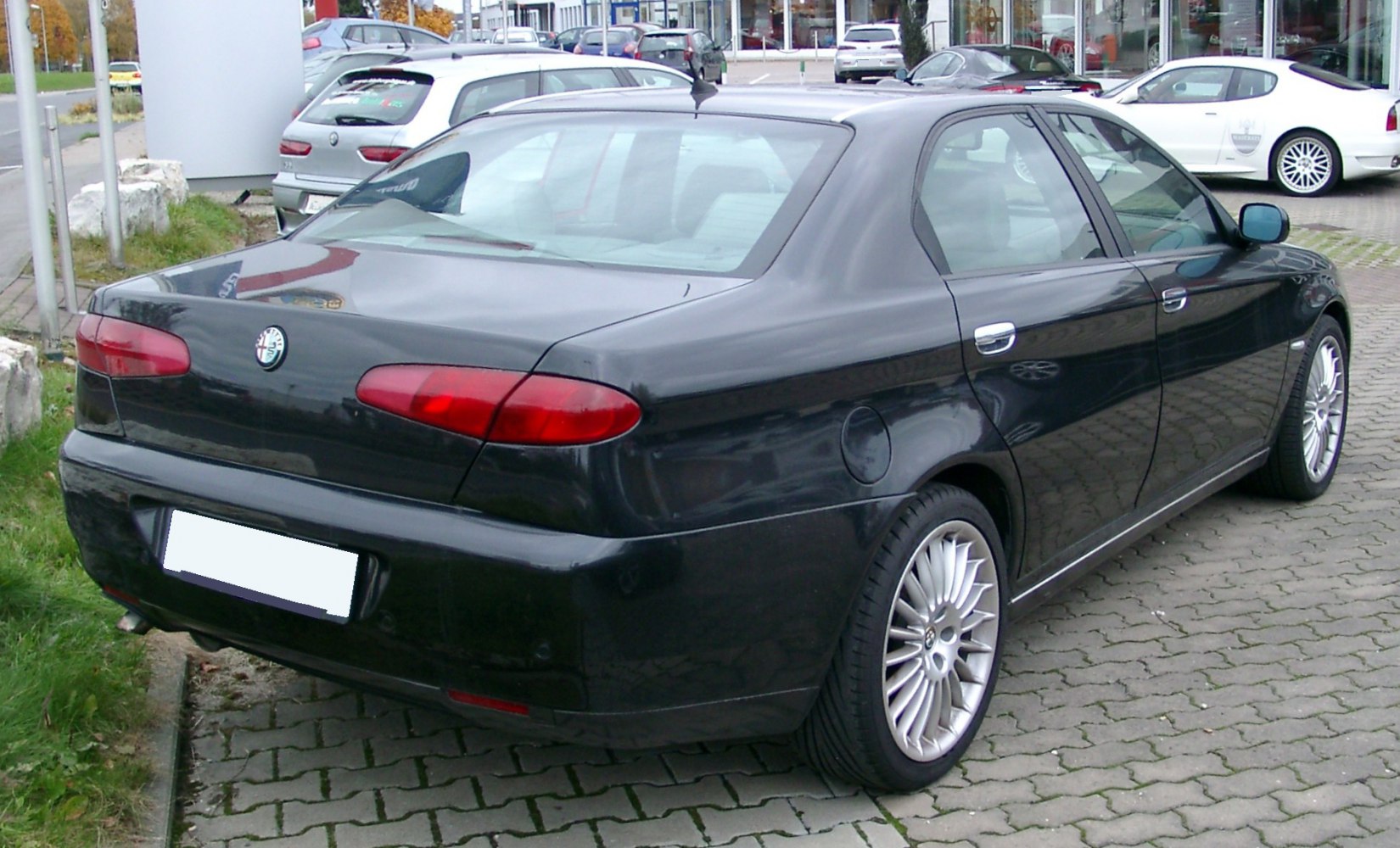 Sleek black sedan rear view with distinctive taillights and alloy wheels