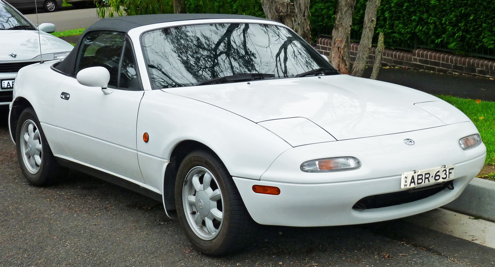 White convertible with pop-up headlights and classic alloy wheels