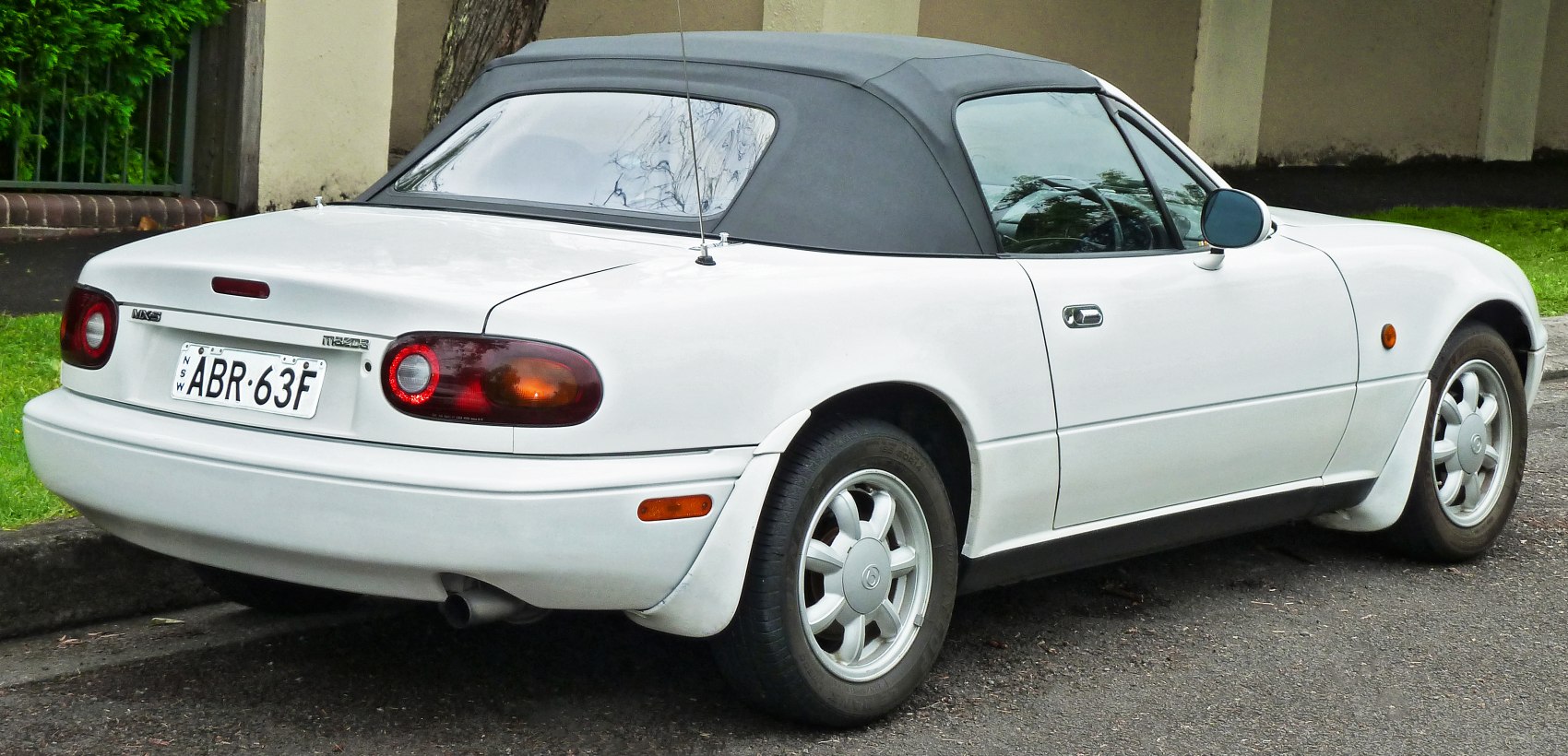 Rear and side view of convertible with soft top and alloy wheels