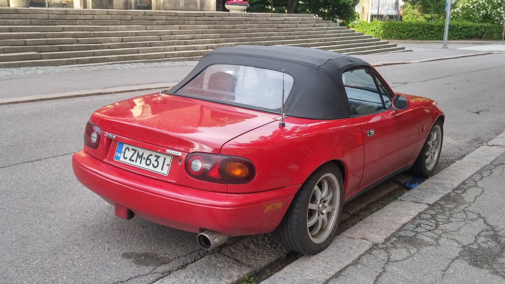 Rear view of red convertible with soft top and round taillights